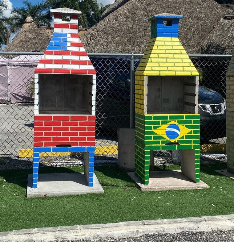 Duas churrasqueiras compactas com pinturas personalizadas em vermelho, branco, azul, verde e amarelo.
